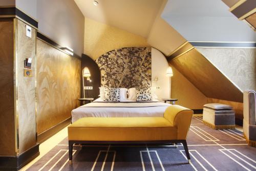 巴黎快乐文化纳比酒店的酒店客房带床和黄色长椅