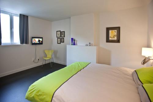 根特德拉布街2号公寓的一间卧室配有一张带绿毯的床