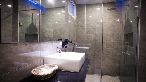 万象家庭精品酒店 的一间带水槽和玻璃淋浴的浴室