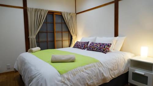白马村白马和谐之家度假屋的一间卧室配有一张带绿毯的大床