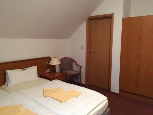 希尔泽祖尔克隆酒店的一间卧室配有一张床,上面有两条毛巾