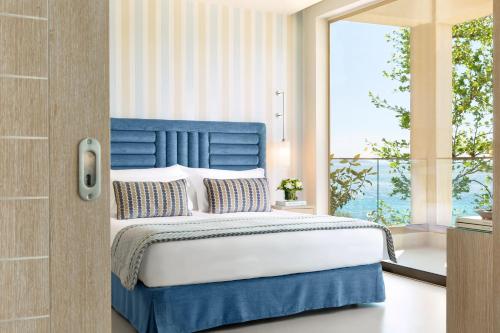 尼亚·蒙达尼亚伊卡斯大洋洲度假村的卧室配有蓝色和白色的床和窗户。