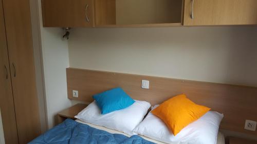 洛萨皮内塔AdriaCamp Mobile Homes Rosepineta的房间里的床上有两个枕头