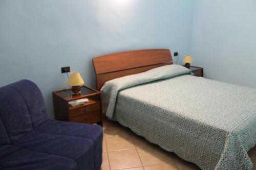 克罗托内Rose Apartment的一间卧室配有一张床和一张蓝色椅子