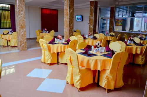 达累斯萨拉姆银色天堂酒店的宴会厅设有黄色桌子和黄色椅子