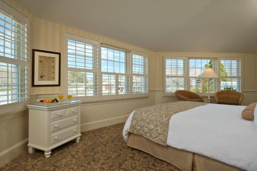 查塔姆Chatham Wayside Inn的卧室配有白色的床和窗户。