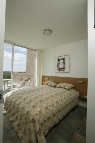 罗莫柯克比勒姆快乐度假酒店的一间卧室设有一张大床和一个大窗户