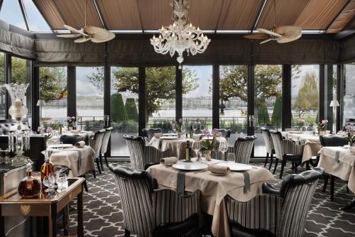 日内瓦丹格利特酒店的一间带桌椅和吊灯的餐厅