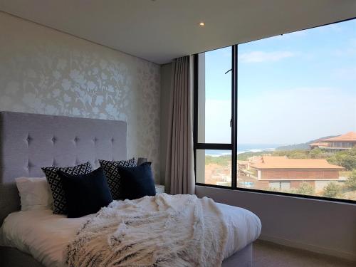 巴利托Zimbali Suites 507的一间卧室设有一张床和一个大窗户