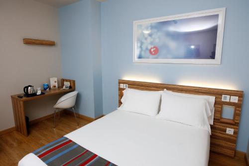 马尼塞斯瓦伦西亚机场旅程住宿的卧室配有白色的床和桌椅
