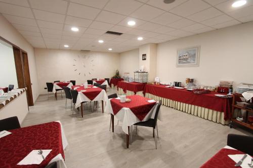 比耶拉欧罗巴酒店 的餐厅设有红色的桌椅和墙上的时钟