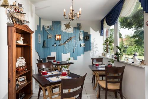 普雷罗Frühstückspension Landhaus Lange的一间配备有桌椅的用餐室和蓝色的墙壁