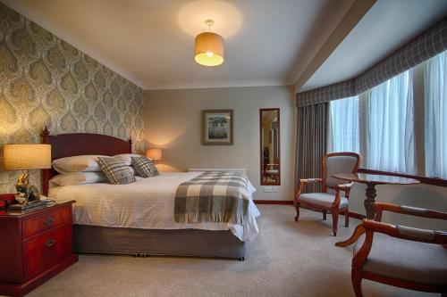 因弗鲁里Strathburn Hotel Inverurie by Compass Hospitality的一间卧室配有一张床、一张桌子和一把椅子