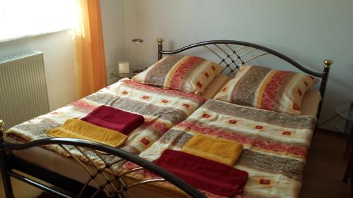 TussenhausenFerienwohnung Baur的床上配有色彩缤纷的毯子和枕头