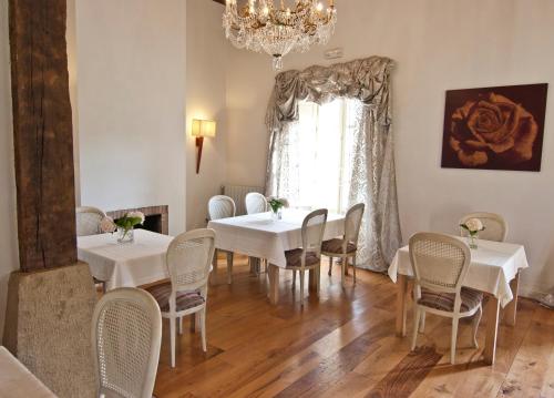 列尔加内斯Posada Villa Esperanza的一间配备有白色桌椅和吊灯的餐厅