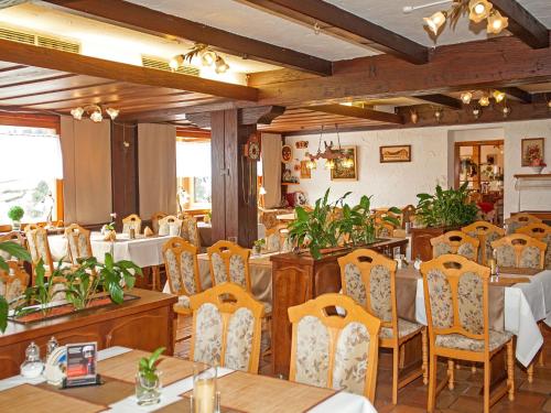 艾森巴哈Waldhotel Auerhahn B&B Bed & Breakfast的一间在房间内配有桌椅的餐厅