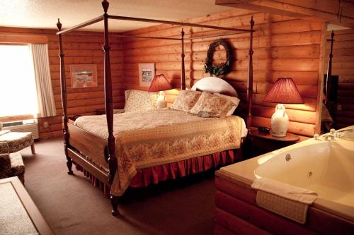 Mequon密尔沃基地区美克旺贝蒙特套房汽车旅馆的一间卧室配有一张床和浴缸