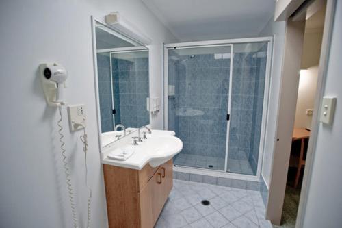 洛坎普顿中心点汽车旅馆的白色的浴室设有水槽和淋浴。