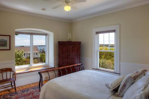 布斯贝港Harbor House Inn的一间卧室设有一张床和两个窗户。