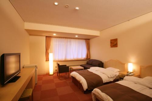 南砺五大阪旅馆的酒店客房设有两张床和一台平面电视。