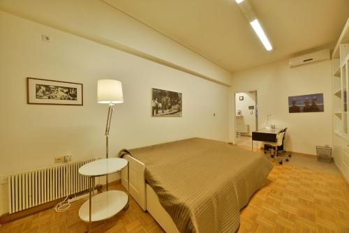 雅典柯洛纳基建筑师设计师公寓的一间卧室配有一张床、一张桌子和一张书桌