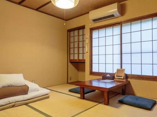 京都祗园旅馆Q-BEH的客房设有桌子、床和窗户。