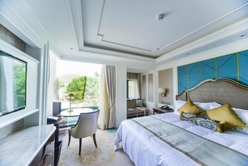 上海西郊宾馆的一间卧室配有一张特大号床和一张书桌