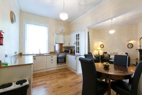 都柏林都柏林短期租赁公寓的厨房以及带桌椅的起居室。