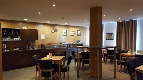 埃姆登科勒巴哈霍夫酒店的一间带桌椅的餐厅和一间厨房