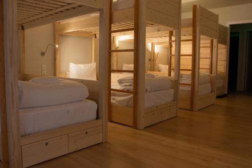 圣玛丽亚大德费拉Feira Hostel & Suites的客房配有4张双层床和白色枕头。