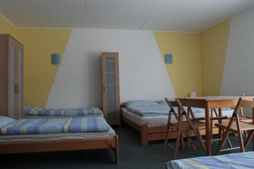利波瓦拉尼penzion Pomněnka的一间设有两张床和一张桌子及椅子的房间