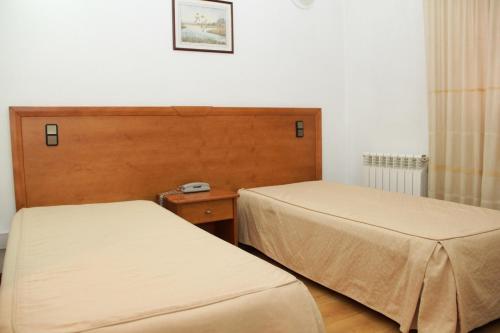 塞洛里库达贝拉公园住宅酒店的一间设有两张床的客房和墙上的时钟