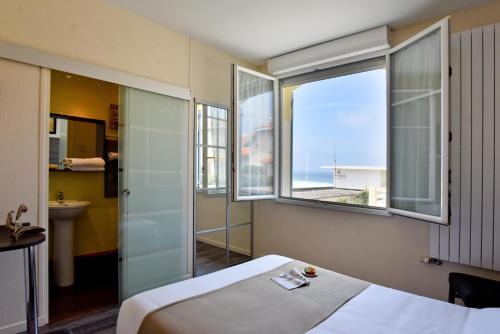 米尼赞海滩Logis Hotel de France的酒店客房设有一张床,享有海景。