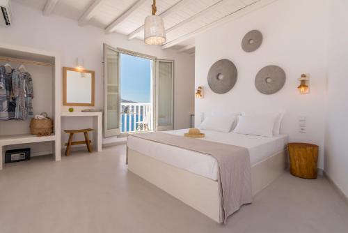 普拉卡米洛斯Halara Studios的一间白色卧室,配有床和阳台