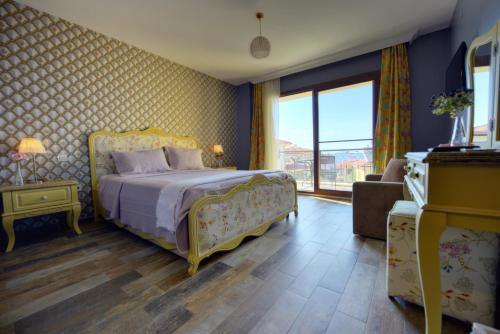艾瓦勒克Nilüfer Butik Otel的一间卧室设有一张床和一个大窗户