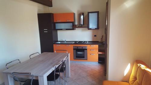 维拉普特祖Corallo casa vacanza的一个带木桌的厨房和一个带橙色橱柜的厨房