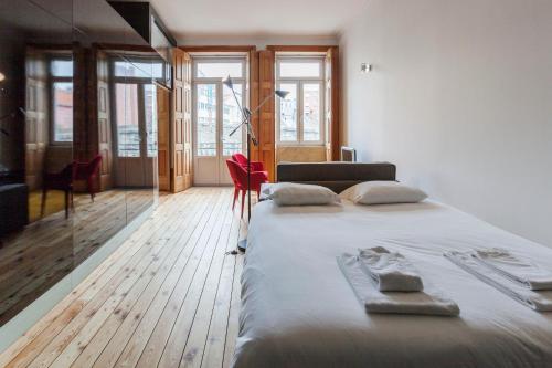波尔图Go2oporto - Fontainhas Apartments的一间卧室设有一张大床、木地板和窗户。