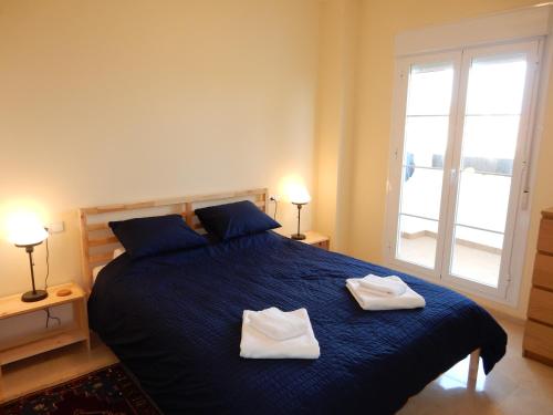 阿罗约德拉迷雅Benalmadena Hill Views 1B的一间卧室配有蓝色的床和2条毛巾