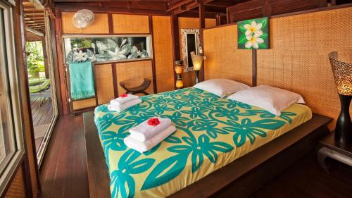 帕佩托艾Robinson's Cove Villas - Deluxe Wallis Villa的一间卧室配有带毛巾的床