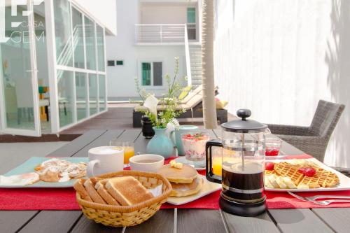 普拉亚卡门Casa Gem B&B的一张桌子,上面有早餐食品和饮料