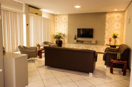 布吕斯克Hotel Veneza的带沙发和平板电视的等候室