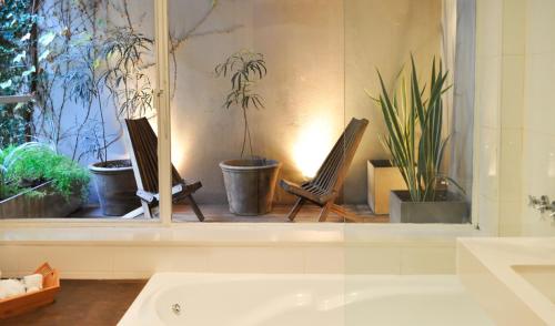 布宜诺斯艾利斯麦特瑞精品酒店的浴室设有窗户,配有两把椅子和植物