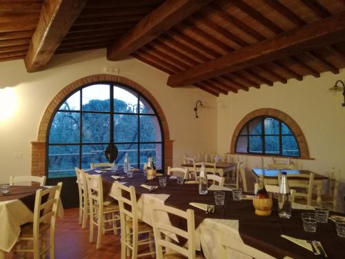 帕拉伊阿Agriturismo Il Loghino的用餐室配有桌椅和大窗户