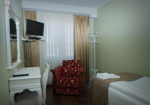 伊萨尔米Hotel Golden Dome Iisalmi的客房设有一张床、一张桌子和一把椅子。