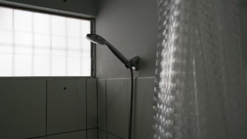 帕拉马里博Tropico Inn的带淋浴的浴室,带窗户
