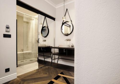 卢布尔雅那Kollmann Rooms and Apartments的浴室设有水槽和墙上的两面镜子