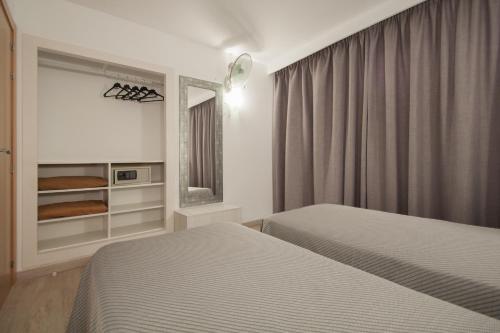 马盖鲁夫索尔伊维拉公寓的酒店客房,设有两张床和镜子