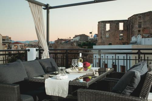 干尼亚Nival Luxury Suites的阳台的天井配有桌椅
