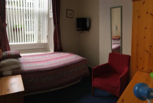 阿伯丁Arkaig Guest House的卧室配有床、椅子和窗户。