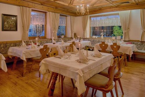 布鲁尼科吉斯巴克酒店的一间设有白色桌椅和窗户的用餐室